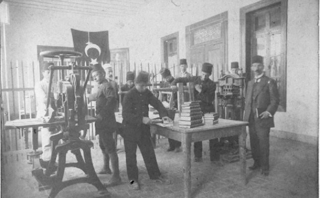 People, equipment and books in a printing workshop