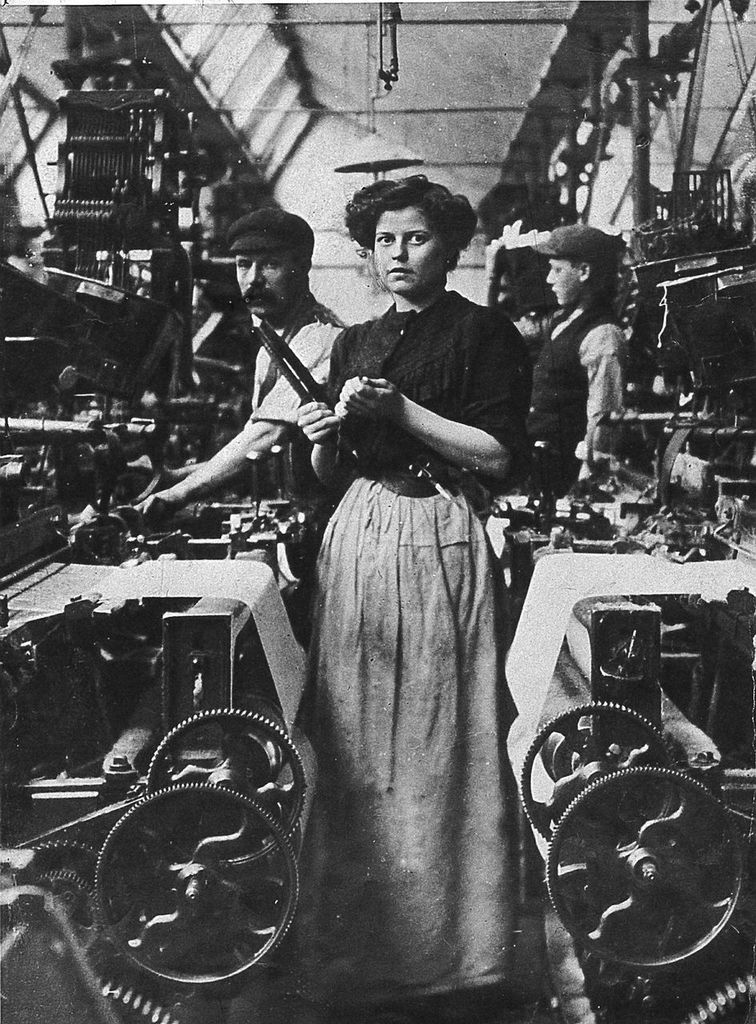 A woman working among textile machines